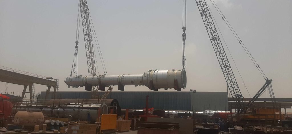 Crane lifting a column during installation at industrial site