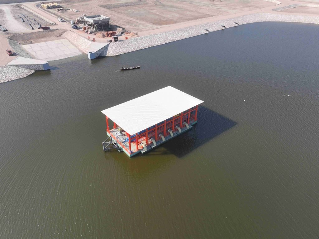 Floating red and white platform in open water, aerial view