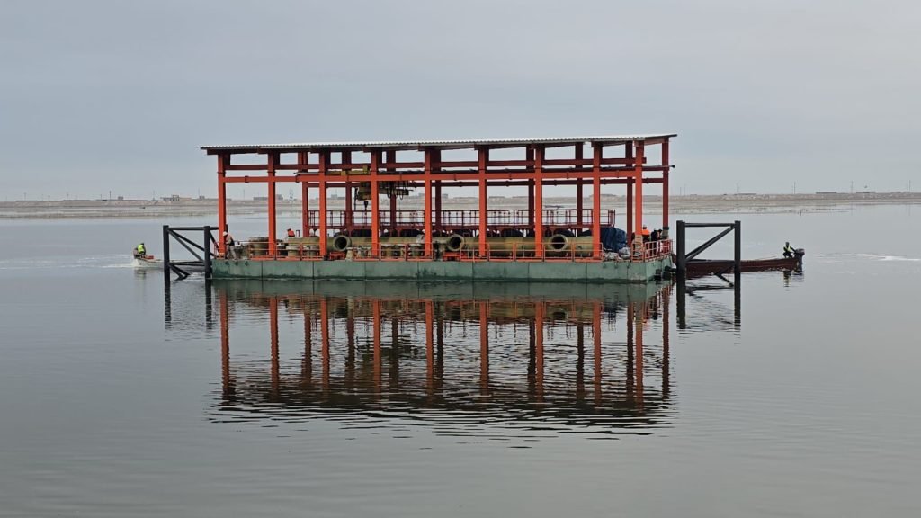 Steel offshore platform frame under construction on calm water.