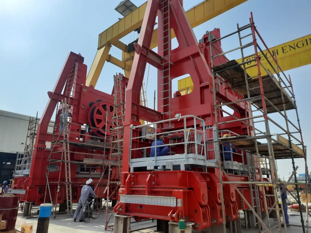 Red heavy-duty offshore cable deployment equipment in yard.
