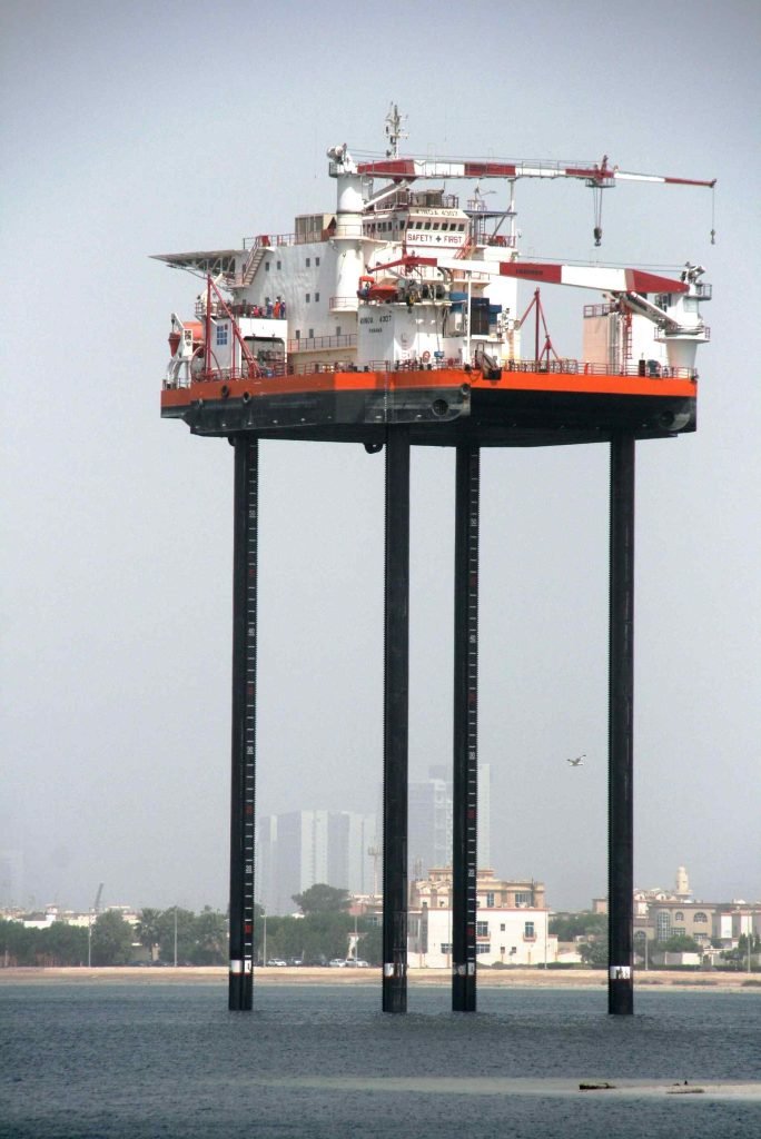 Fully elevated Jack-Up Barge in the water with legs extended.