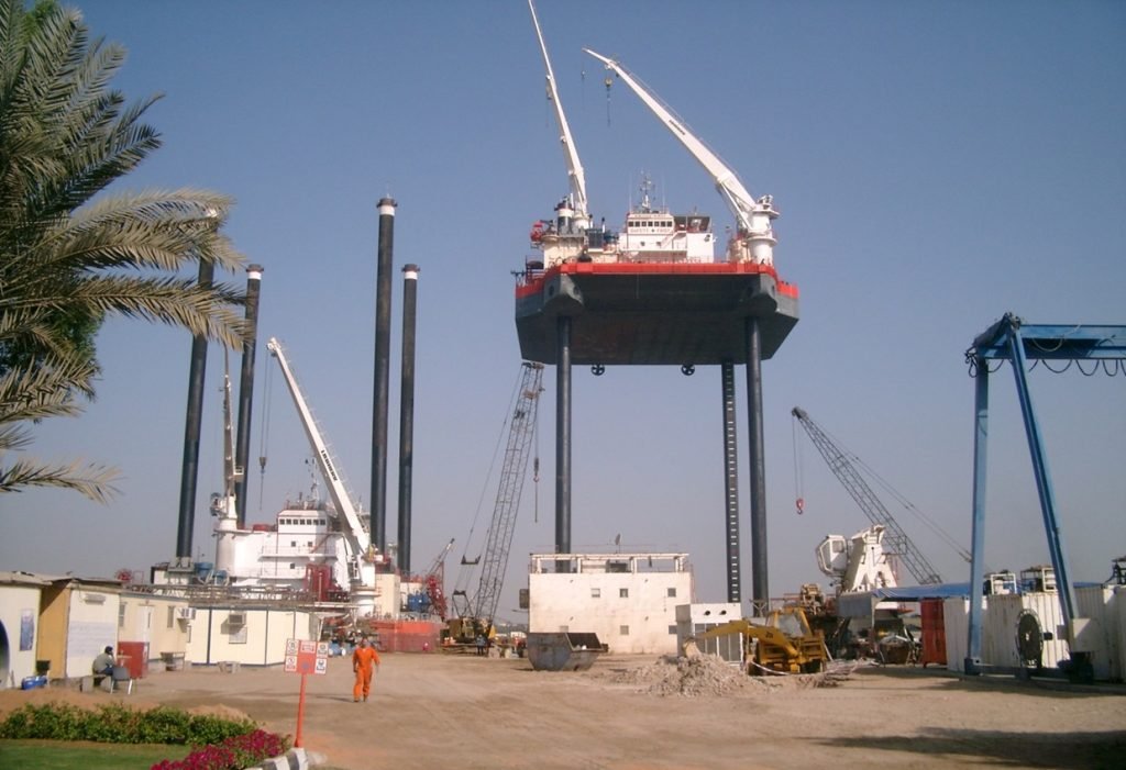 Jack-Up Barge near the shore with cranes and surrounding structures.